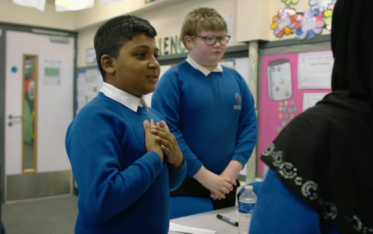 A pupil expressing himself during an activity while his peer listens to him