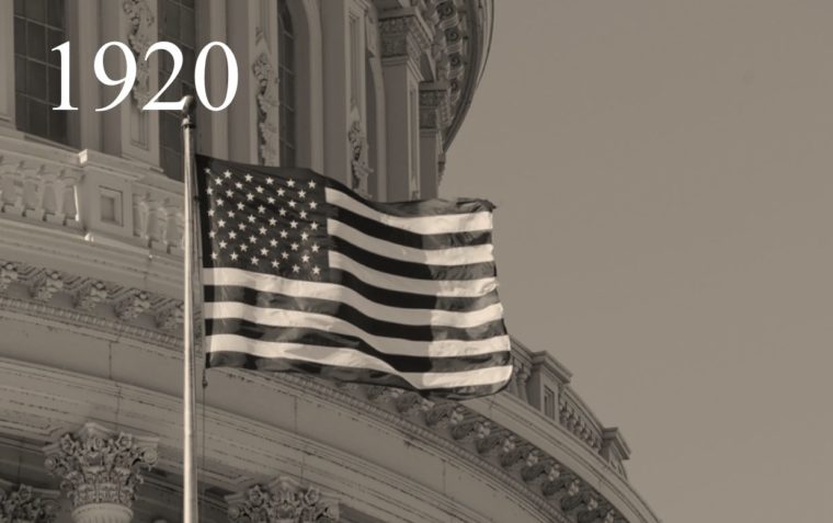 The flag of USA and a building in the background.