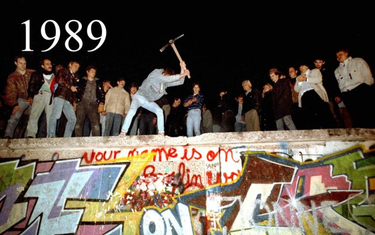 A picture of a graffiti and some men standing at the top.