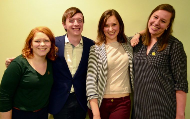 4 people posing and smiling for a picture