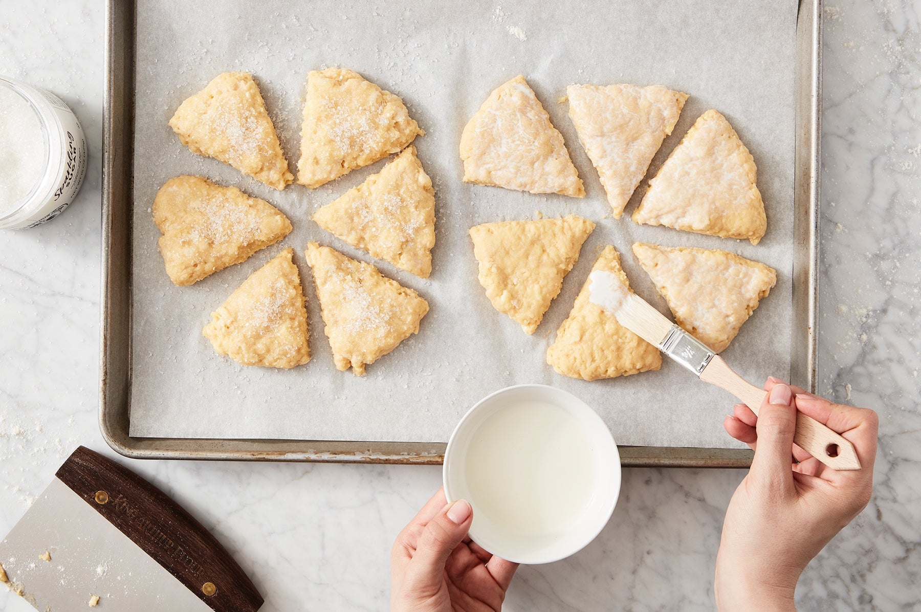 Brushing the tops of unbaked scones with cream