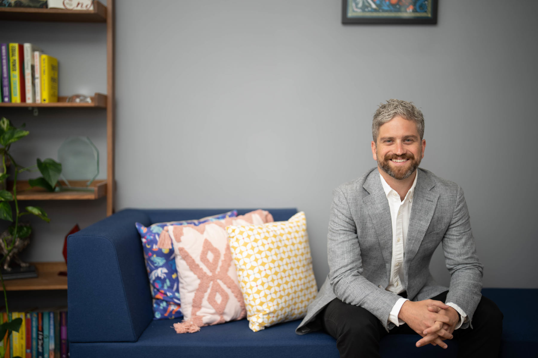 Dan Conway smiling while sitting on a sofa