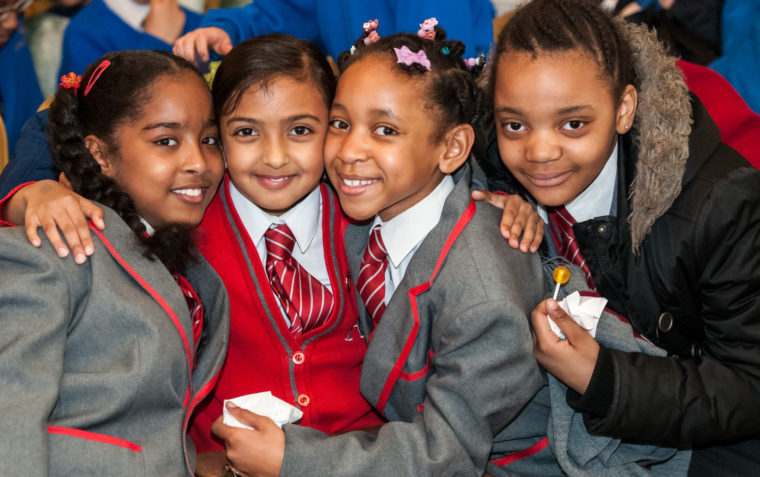 A photo of 4 pupils hugging each other