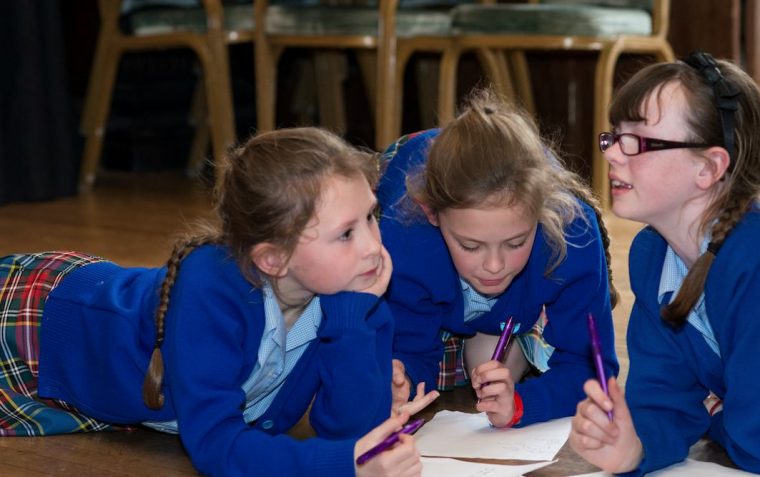 A group of 3 primary school girls planning their workshop ideas