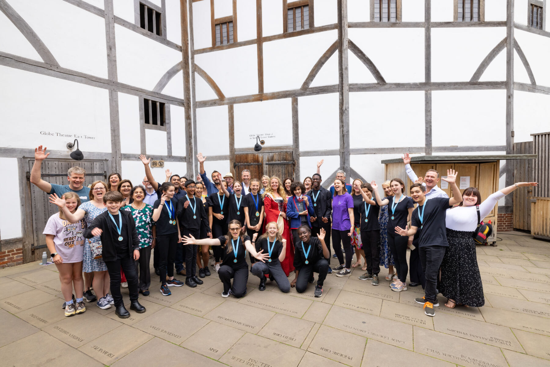 Performing Shakespeare participants standing outside of the Globe theatre