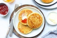 Three buttered sourdough crumpets on a plate.