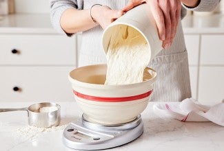 Baker pouring sourdough discard into bowl