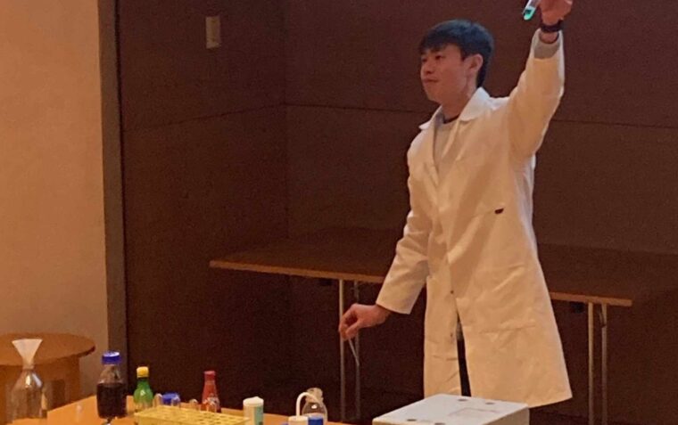 Scientist from the Lindemann Trust showing children a test tube