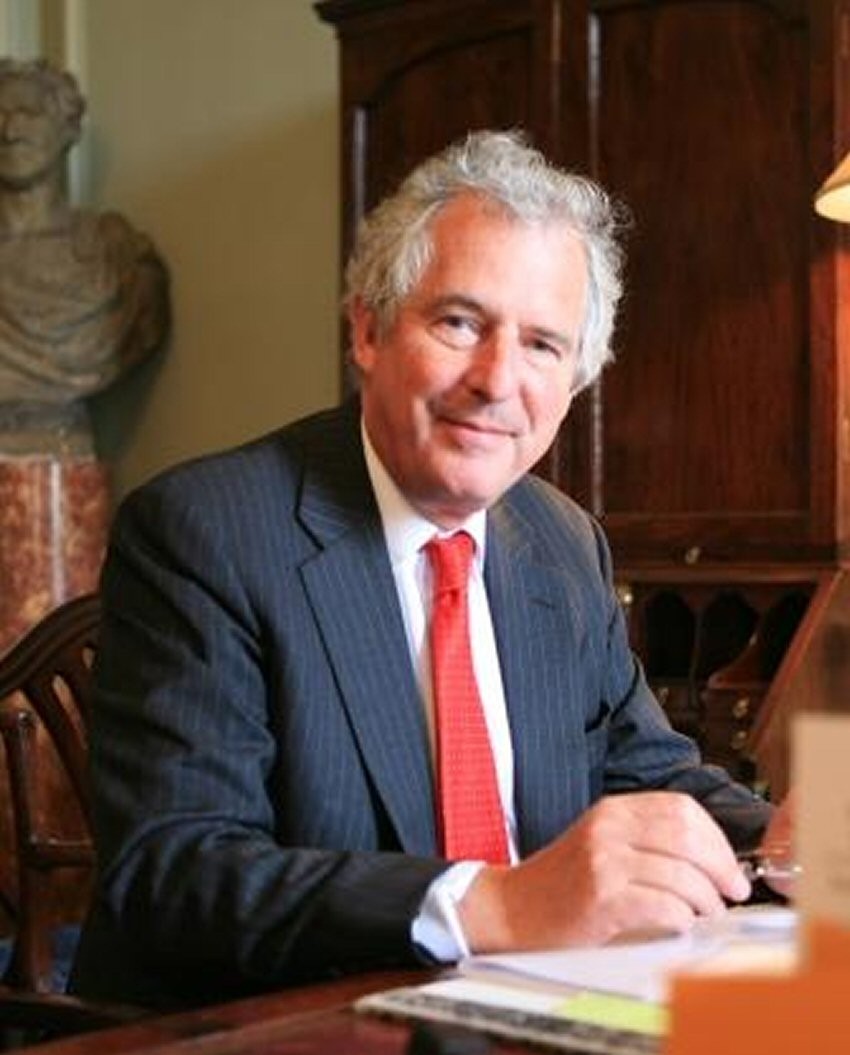 William Waldegrave posing for a photo from his desk